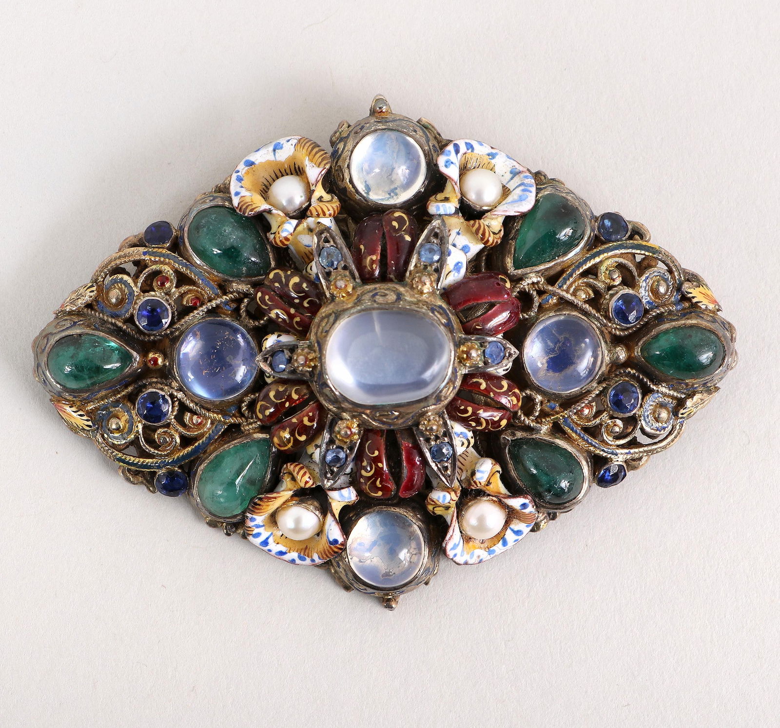 Hungarian Jeweled and Enameled .800 Silver Brooch: Hungarian Jeweled and Enameled .800 Silver Broochof lozenge form, with floral decoration and scrolled designs, having moonstone cabochons, pear-form emerald cabochons, round-cut sapphires, round-cut b