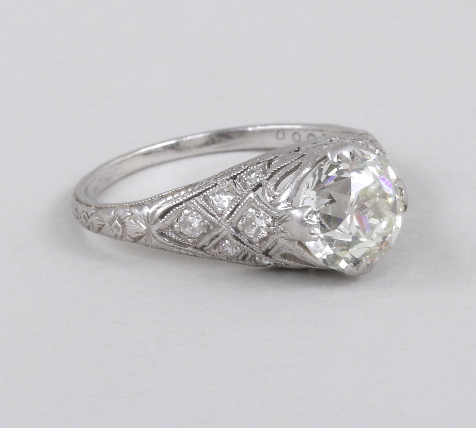 1.6 Carat Diamond Platinum Ring: 1.6 Carat Diamond Platinum Ring having an old mine cut diamond, approximately 1.6 carats (SI2 clarity, M color), prong-set over a pierced gallery with bows, the pierced shoulders each having (6) round