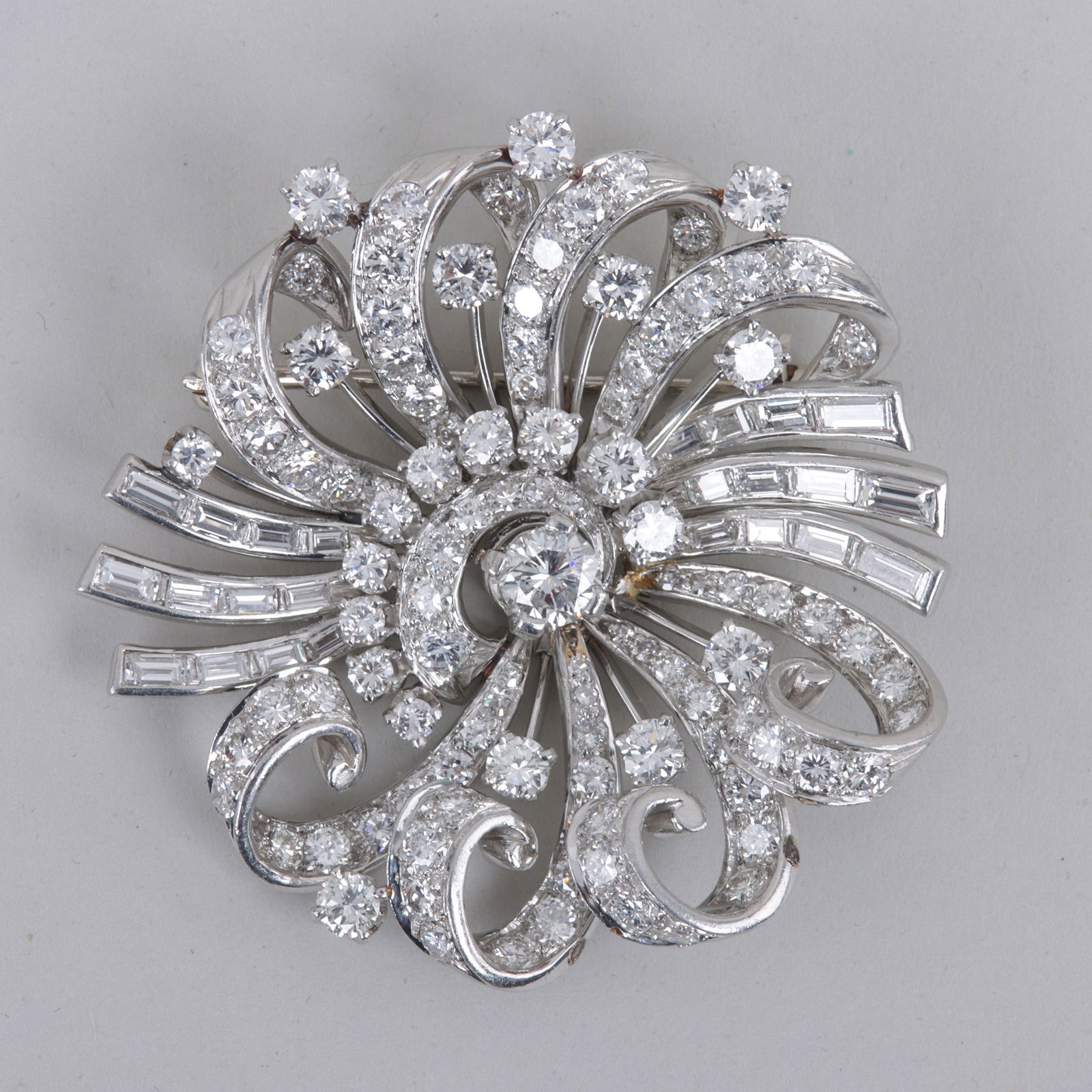 Diamond and Platinum Pendant Brooch: Diamond and Platinum Pendant Broochhaving a round brilliant-cut diamond at center, approximately 0.6 carats, surrounded by a swirl design with (106) smaller round brilliant-cut diamonds and (28) bague