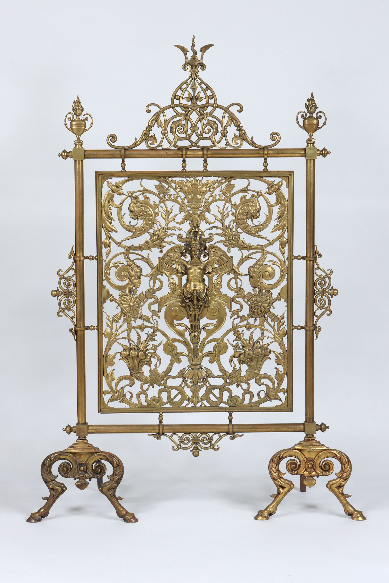 Gilt Bronze and Brass Fireplace Screen: French Empire-Style Gilt Bronze and Brass Fireplace Screenhaving scrolled openwork designs, the crest topped by a stylized flame finial and flanked by urn flame finials, the central panel having a win