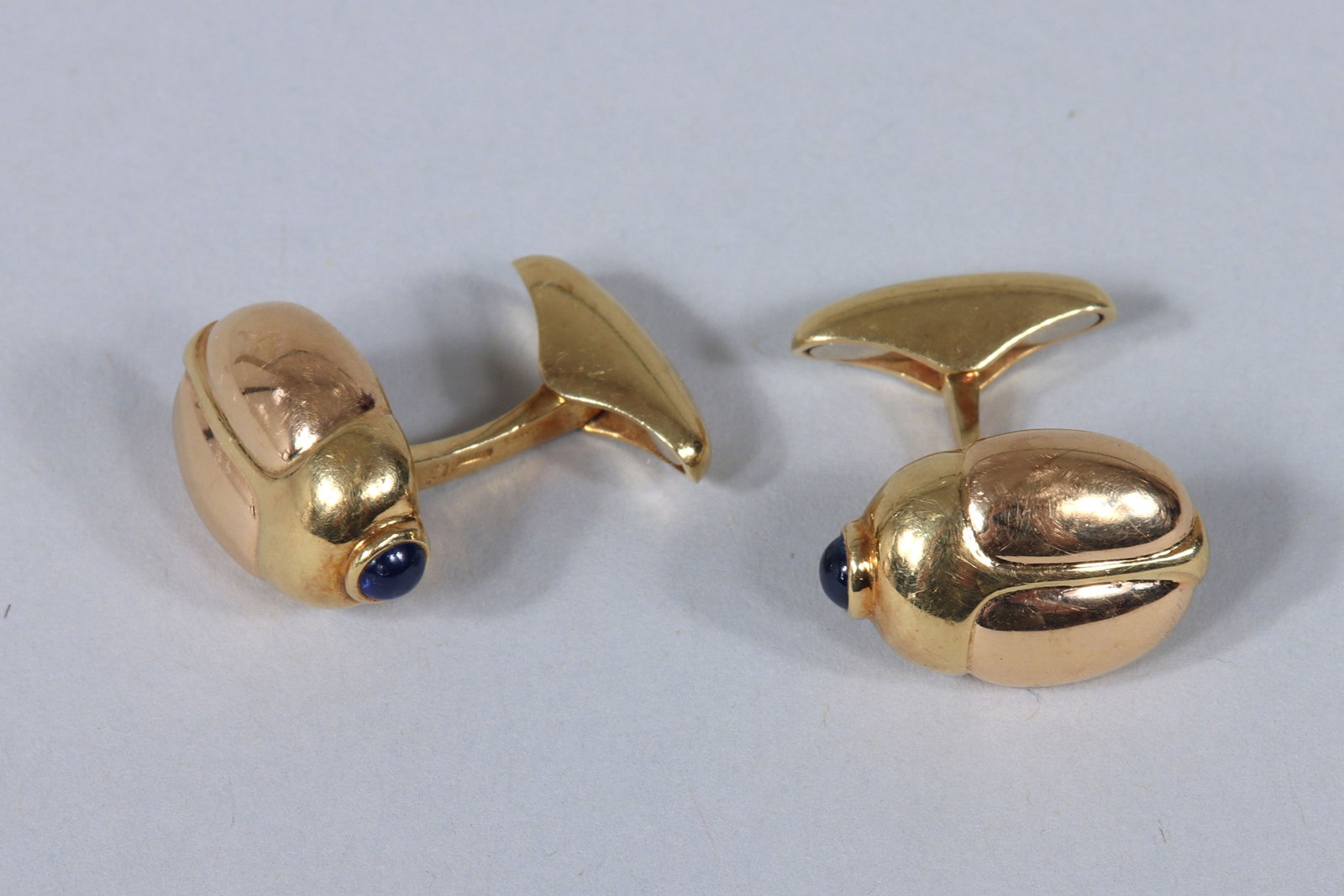 Pair of 18k Gold Beetle Cufflinks: Pair of 18k Gold Beetle Cufflinks in the form of beetles, each having a round sapphire cabochon bezel-set on the beetle's head, Italy, marked. Total approximate weight 7.2 dwt (11.4 grams)
