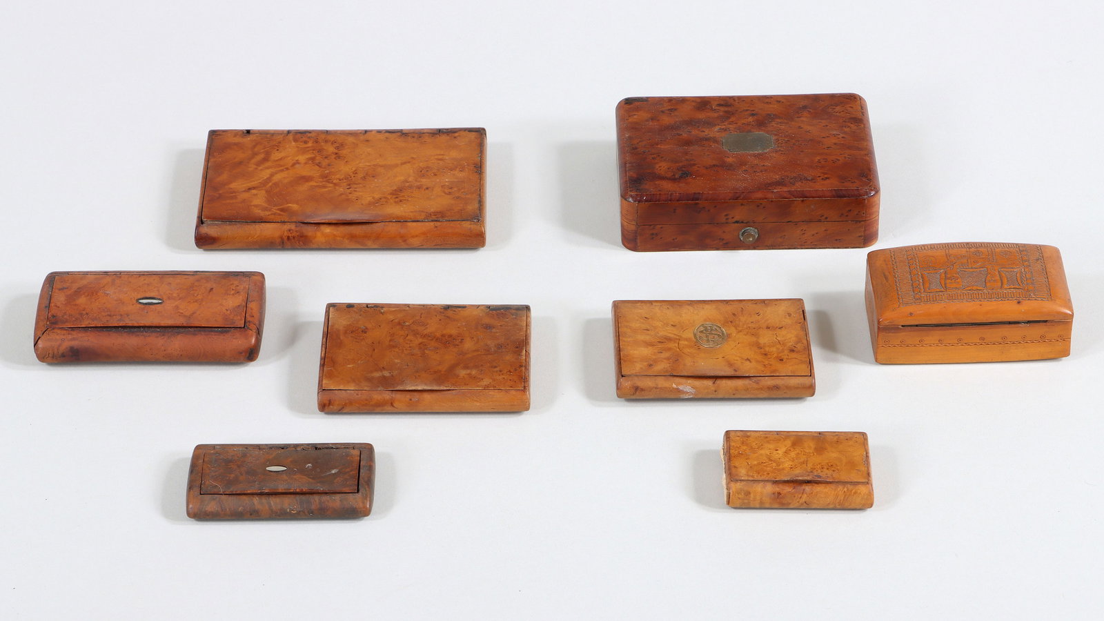 Carved Wood Cigarette Cases and Other Boxes: Group of (8) Carved Wood Cigarette Cases and Other Boxes most in bird's eye maple, all with hinged lids, to include: Russian or Eastern European box with hand-carved decoration, having lid with geomet