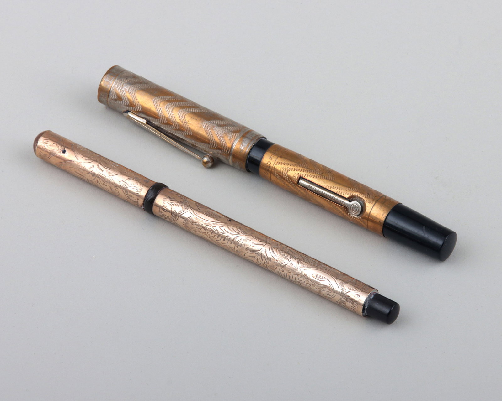 Group of (2) Fountain Pens: Group of (2) Fountain Pens with metal nibs, to include: English pen in 9k gold case with engraved foliate design, possibly by Albert Baker & Co., Birmingham or London, early 20th century, hallmarked w