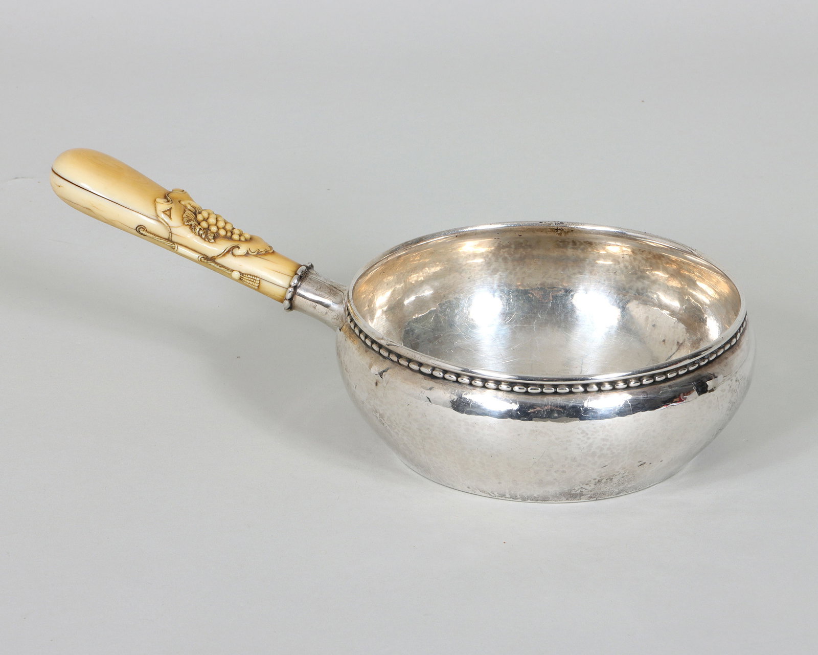 Georg Jensen Sterling Silver Casserole: Georg Jensen Sterling Silver Casserole probably late 1920s, having hammered sterling silver bowl with beaded top border and carved side handle with grapes over a shaped cartouche and faux rope with ta