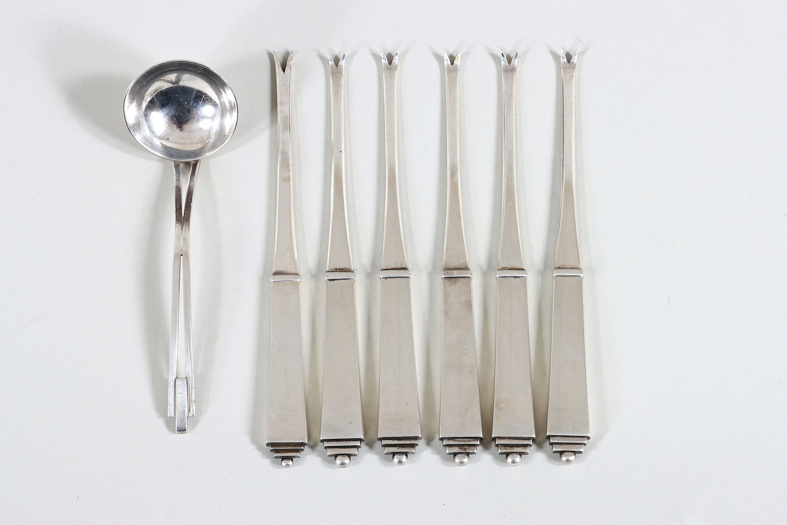 Group of (7) Georg Jensen Sterling: Group of (7) Georg Jensen Sterling Silver Flatware to include: set of (6) lobster picks in the Pyramid pattern, marked; and a ladle in an unidentified pattern, possibly designed by Adda Husted-Anderse