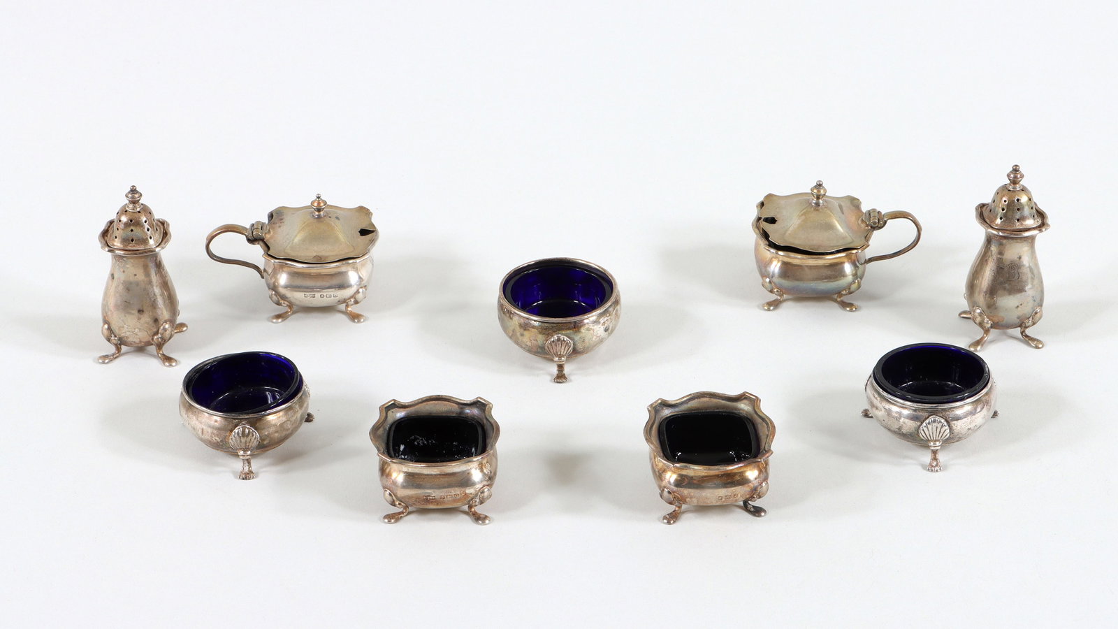 Sterling Salt Cellars, Pepper Shakers, and Mustard Pots: Group of (9) Sterling Silver Salt Cellars, Pepper Shakers, and Mustard Pots to include: George V or George VI six-piece condiment set, Mappin & Webb Ltd., Birmingham, 1913 or 1938, all of square form,