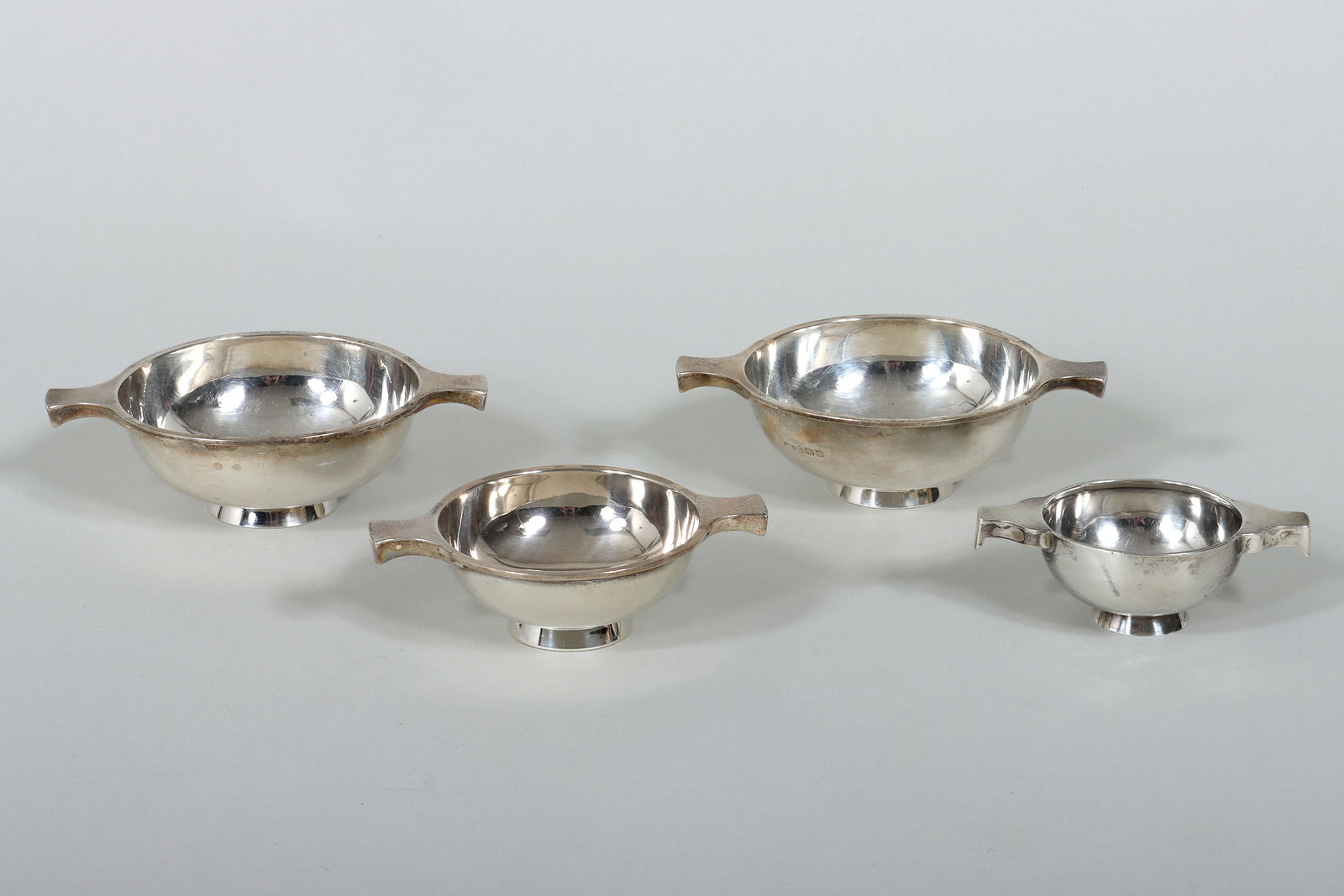 English and Scottish Sterling Silver Quaichs: Group of (4) English and Scottish Sterling Silver Quaichs all with twin handles, to include: Scottish George VI miniature quaich, Edward & Sons, Glasgow, 1938, (minor dents); Scottish George V small q