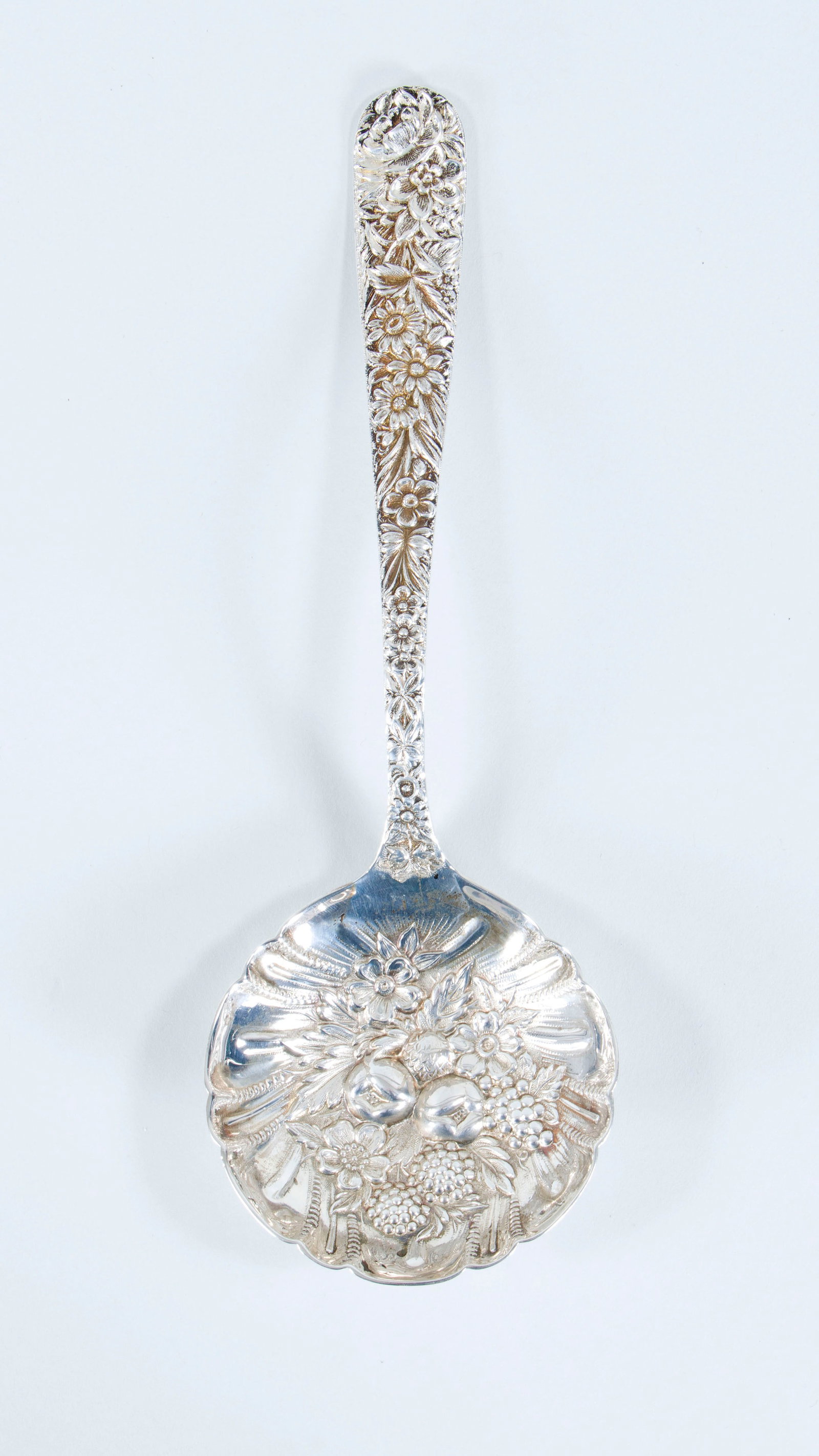 S. Kirk & Son Sterling Silver: S. Kirk & Son Sterling Silver "Repousse" Berry/Casserole Spoon in the Repousse pattern, possibly 19th century, having scalloped bowl with repousse fruit and flowers at center, marked. Length 9 1/4 in.
