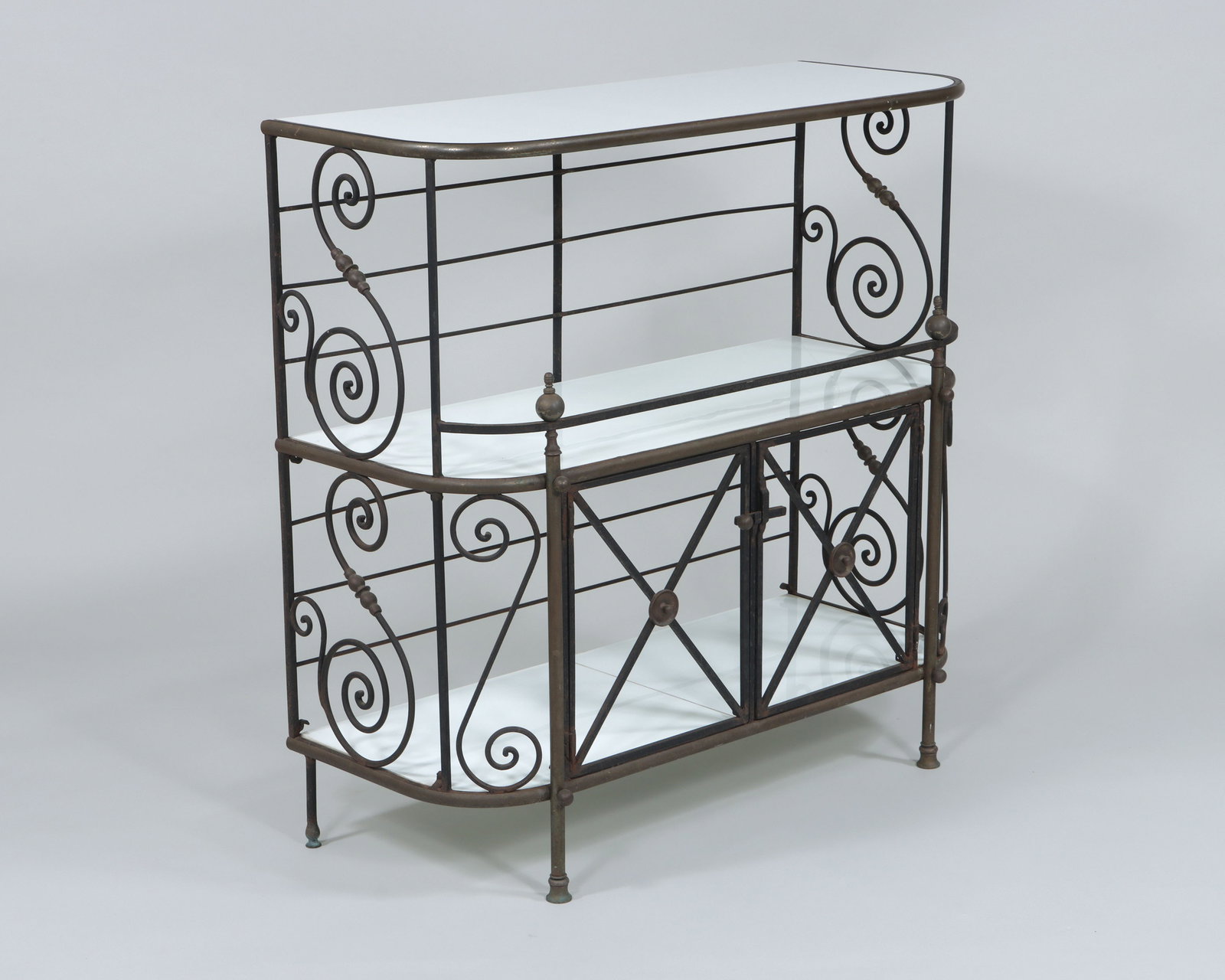Wrought Iron Baker's Rack or Sideboard: Wrought Iron Baker's Rack or Sideboard having three milk glass shelves, brass trim and finials, S-scroll designs, and bottom cupboard with two latched doors and curtain rod brackets. 39 3/4 x 40 1/4 x