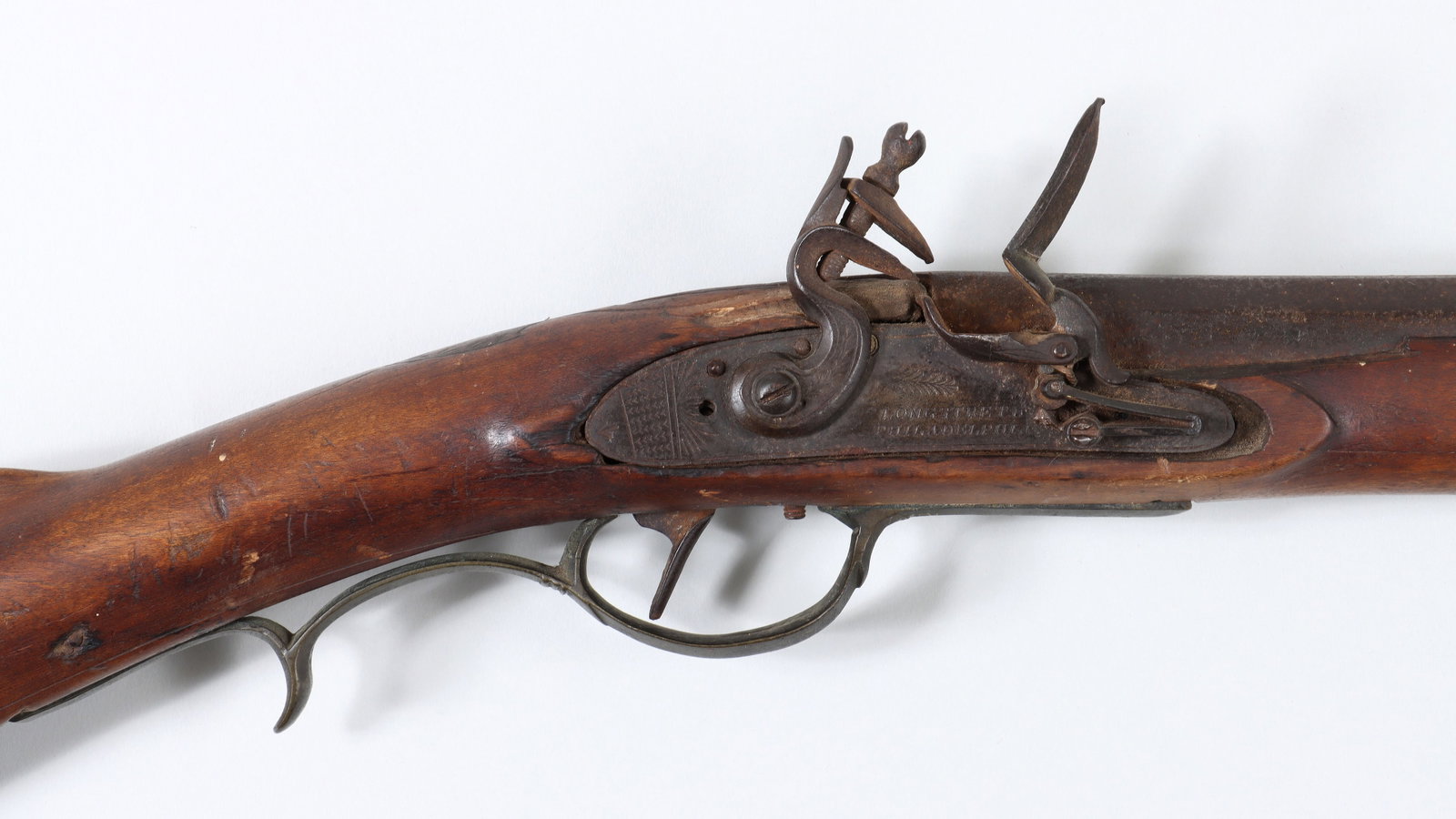 Pennsylvania Long Gun with a Smooth Bore, in 56 Caliber: Pennsylvania Long Gun with a Smooth Bore, in 56 Caliber The octagon barrel measures 38" with a V-notch rear sight and blade front. The flintlock is marked "Longstreth, Philadelphia", with a small amou