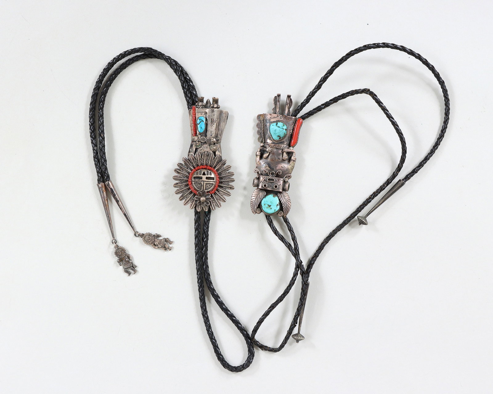 Native American Sterling Katsina and Kachina Bolo Ties: Group of (2) Native American Sterling Silver Katsina and Kachina Bolo Ties having sterling silver figural bolos with applied turquoise and coral, on braided leather cords ending in sterling silver tip