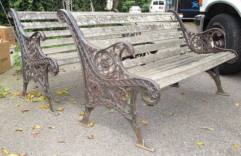 Pair of cast iron and wood slate garden benches: Pair of cast iron and wood slate garden benches, 31''h, 50''w, 24''d; most wood slats need to be replaced.