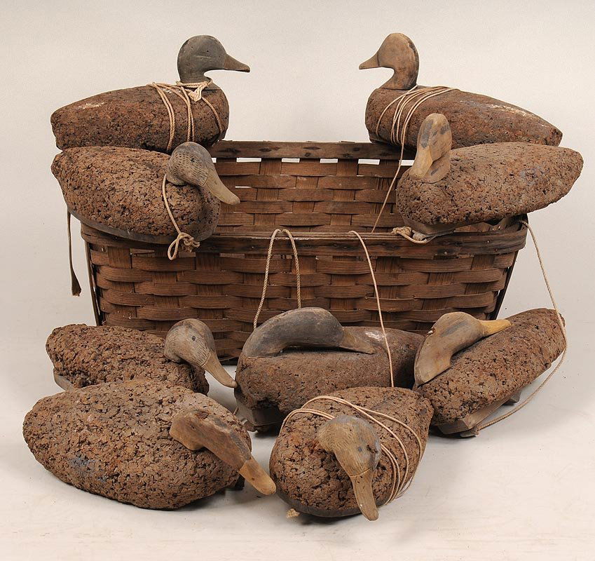 Group of (9) cork black duck decoys in a splint basket: Group of (9) cork black duck decoys in a splint basket from the Charles Belt Rig, Shinnecock Bay, L. I.; as found.