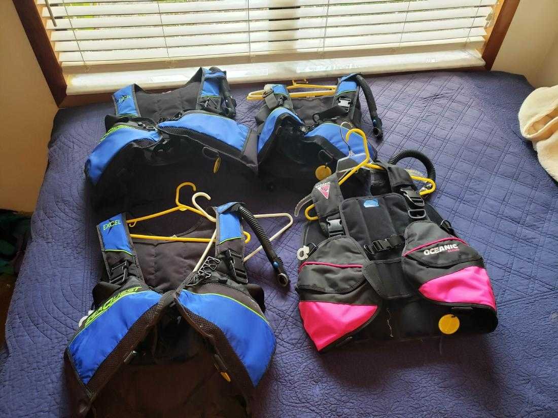 FOUR SCUBA BUOYANCY VESTS, SEAQUEST, OCEANIC BRANDS: Seaquest & Oceanic brand buoyancy compensator vests, sized as follows....medium....extra large.....small........medium/large.