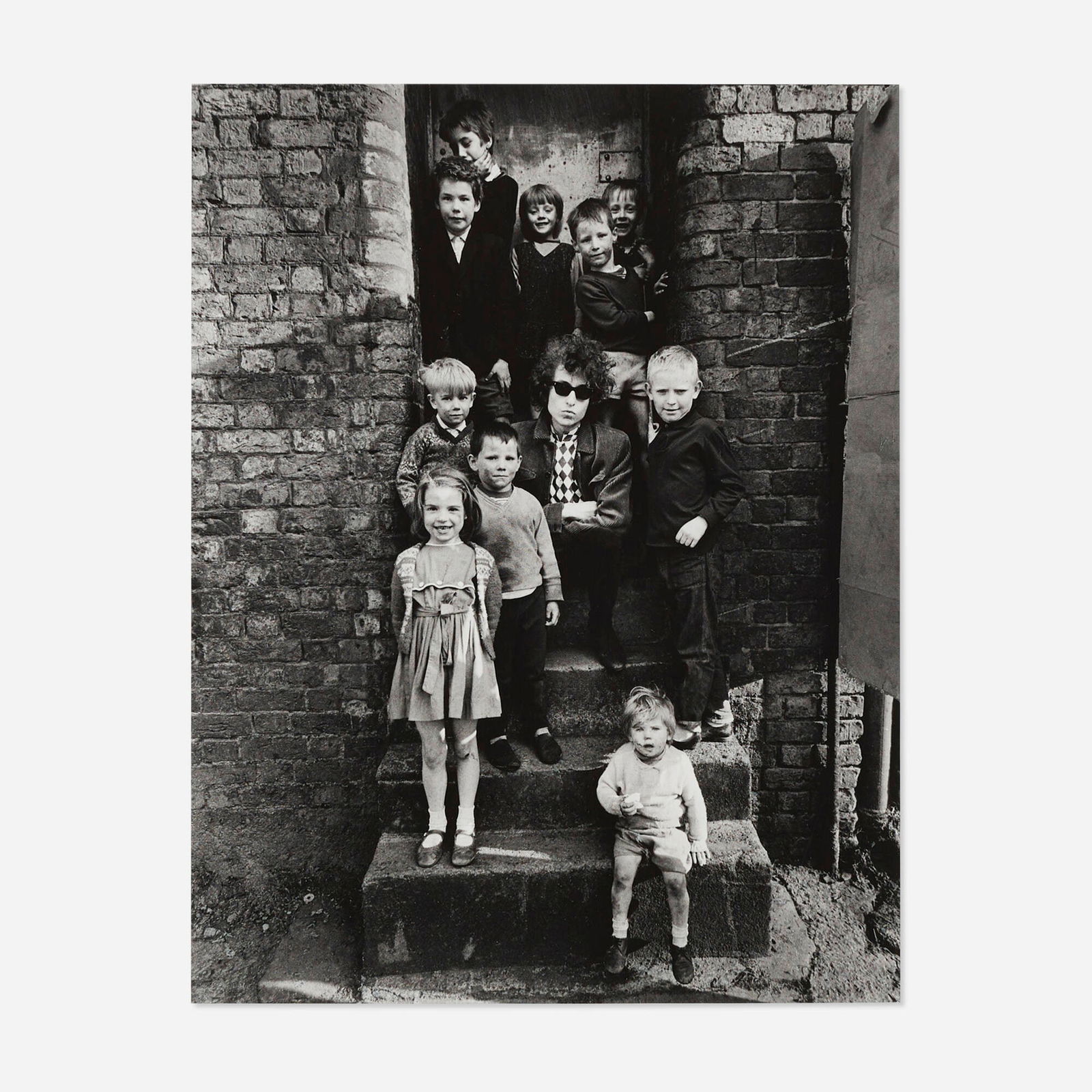 Barry Feinstein, Bob Dylan, (On Steps with Children), Liverpool, England: Barry Feinstein Bob Dylan, (On Steps with Children), Liverpool, England 1966 / printed latergelatin silver print image: 13.25 h x 10.25 w in (34 x 26 cm) sheet: 14 h x 11 w in (36 x 28 cm)