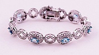 SILVER BRACELET WITH BLUE ZIRCON: BRACELET STERLING SILVER STONE BLUE ZIRCON FINISH POLISHED WEIGHT 10 CTS WEIGHT 26.00GMS SHAPE OV LENGTH 7" COLOR BLUE, STONE WHITE ZIRCON WEIGHT 5 SHAPE RD COLOR WHITE