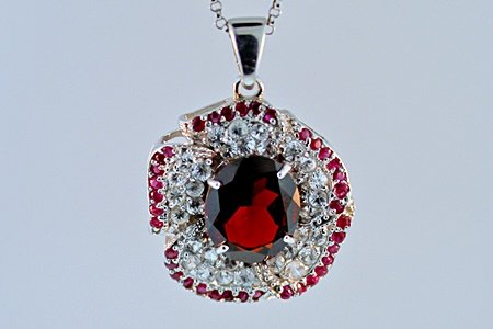 SILVER PENDANT WITH GARNET, RUBY AND WHITE TOPAZ: PENDANT STERLING SILVER STONE GARNET FINISH POLISHED WEIGHT 3 CTS WEIGHT 6.00GMS SHAPE OV LENGTH 1 INCH COLOR RED STONE RUBY WGT 0.25CTS STONE WHITE TOPAZ WGT 1 CTS