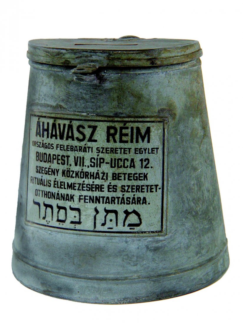 Charity Box. Matan B'Seter. Hungary, 19th Century: Charity box. Hungary. 19th century. Thick, natural-colored metal. Rounded front panel. Flat back. 11 cm. tall. 9.5 diameter at its width. At the top – cover attached with a hinge to the back of the 