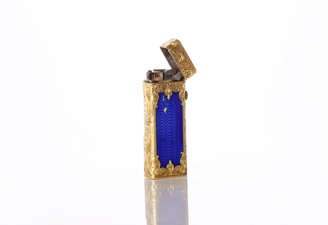 A Gold Lighter Combined with Blue Enamel. 18K Russia: Gold lighter 18K. Stamped 750. Combined with blue enamel. Russia? Delicate and impressive engraving in the shape of leaves.Â Total weight is 102 grams.Â Slight scratches in the enamel. Mechanism