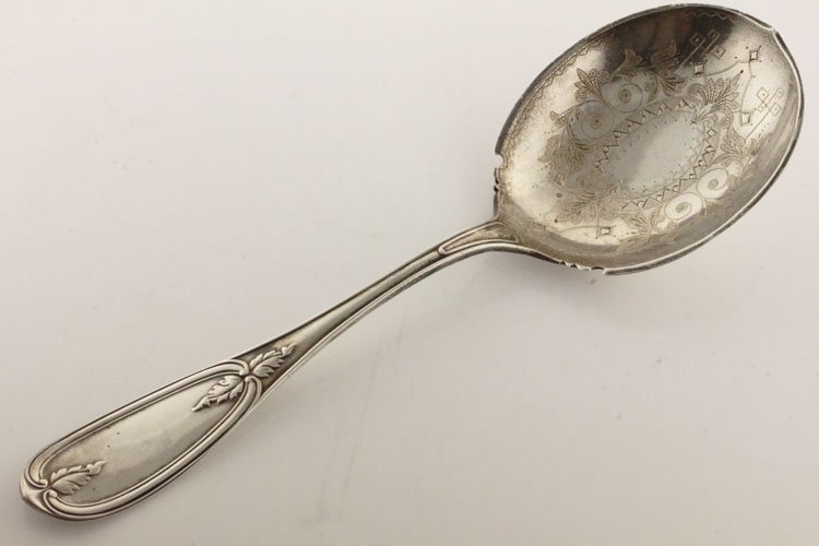 American Coin Silver and Silver Gilt Serving Spoon: EST $100-$150 Circa 1860. Marks: COIN, S.N. STORY. 8 3/4" long. 2.68 troy ounces. The serving spoon in a variation of the Olive pattern with shaped gilt bowl with bright cut foliate and scroll decorat