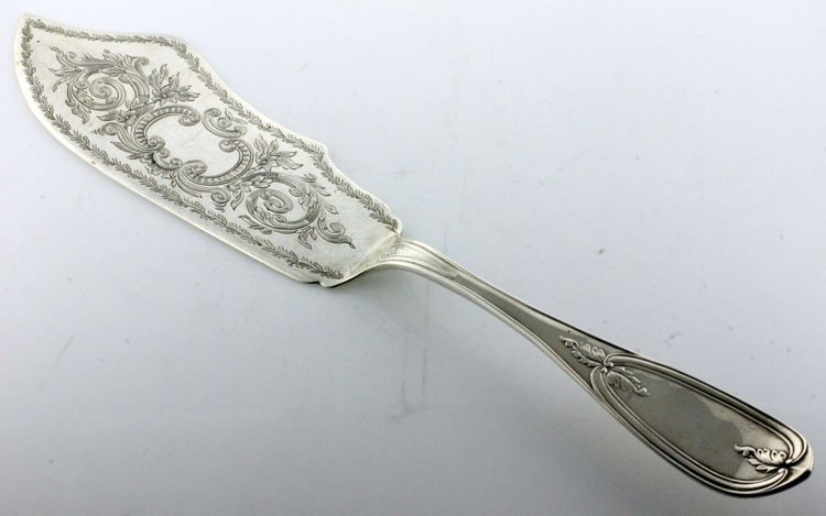 American Silver Cake Server: EST 120-180 Circa 1870. Marks: E, STERLING, JONES, SHREVE, BROWN & CO. 11 3/8" long. 3.54 troy ounces. The cake server in a variation of the Olive pattern, the blade with engraved foliate and scroll d