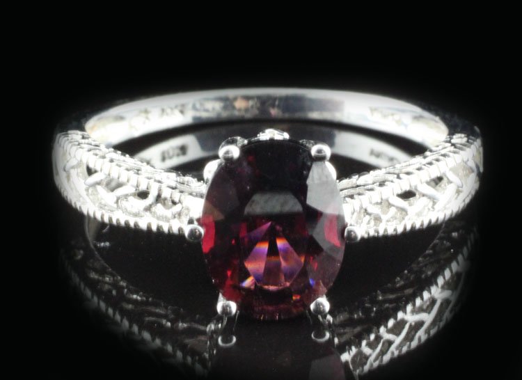 Jewelry-Ladies Garnet Ring in White Gold: Est. $150-$300 Ladies Garnet Ring in White Gold. 10kwg 3.0 grams. Stone is a Garnet 1.75ct approx. Oval faceted. Reddish purple. 7.10 X 9.16 X 3.89mm