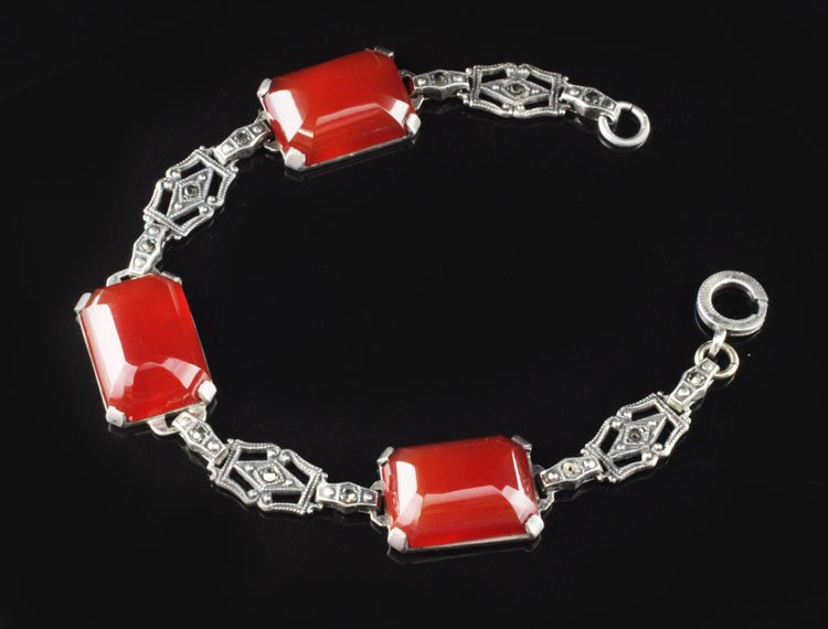Vintage Carnelian & Marcasite Bracelet in Sterling: Est. $125 - 200 Vintage Carnelian & Marcasite Bracelet in Sterling. 16.3 grams total weight. Gemstones are (3) rectangular mixed cut cabachons 17.8 X 12.9mm each approx. 7 1/4 inch long. Clasp needs r