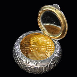 Round Silver Metal Box: Est. $ 30 - 45 Round Silver Metal Box Possibly sterling Vermeil interior, lid with a rope bordered mirror on interior of lid, geometric decoration 1 5/8" diameter x 5/8" high. Circa 1900