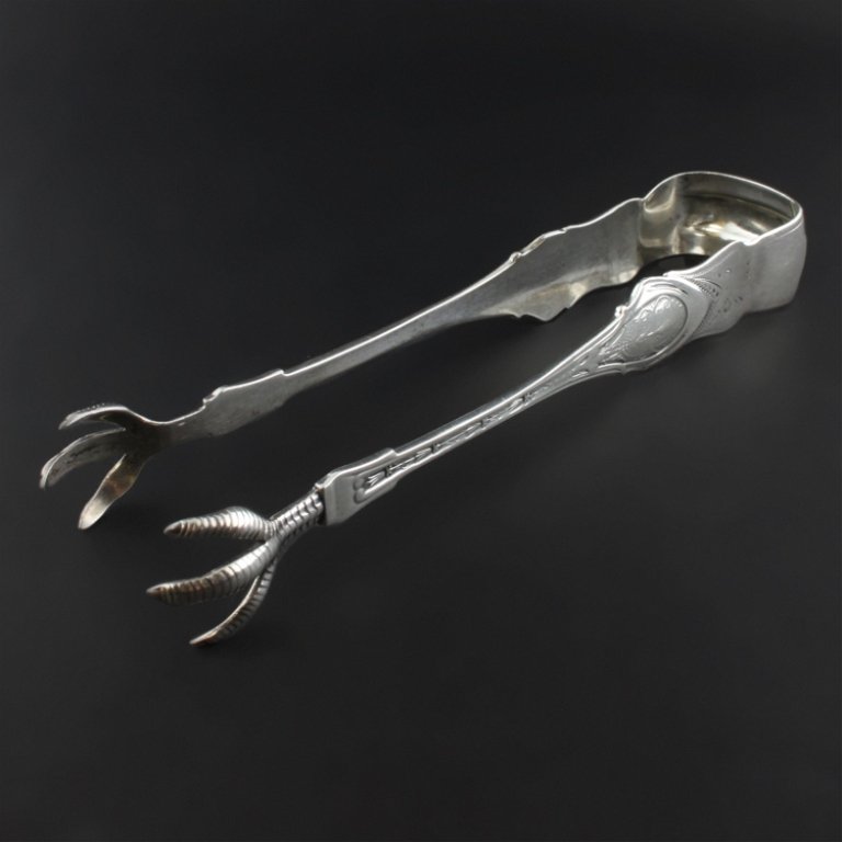 Woods & Hughes Sugar Tongs: Est. $ 40 - 60 Woods & Hughes Sugar Tongs Sterling tongs with Angelo design Pattern. Handles terminate into claws. Monogram on the end appears to be MEMD. Stamped with the Woods & Hughes makers marked