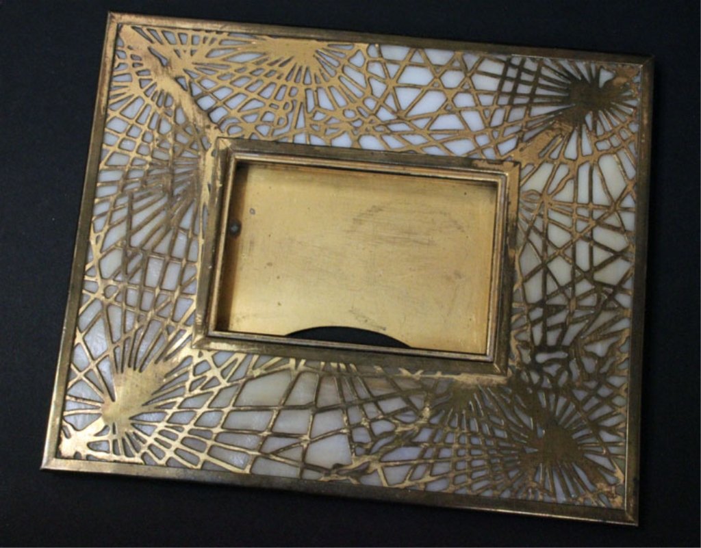 Vintage Tiffany's Calendar Frame: Est. $ 150-225 Vintage Tiffany's Calendar Frame Tiffany Studios calendar frame has etched metal pine needle design against a caramel slag glass background and is finished with a gold patina, the slag 
