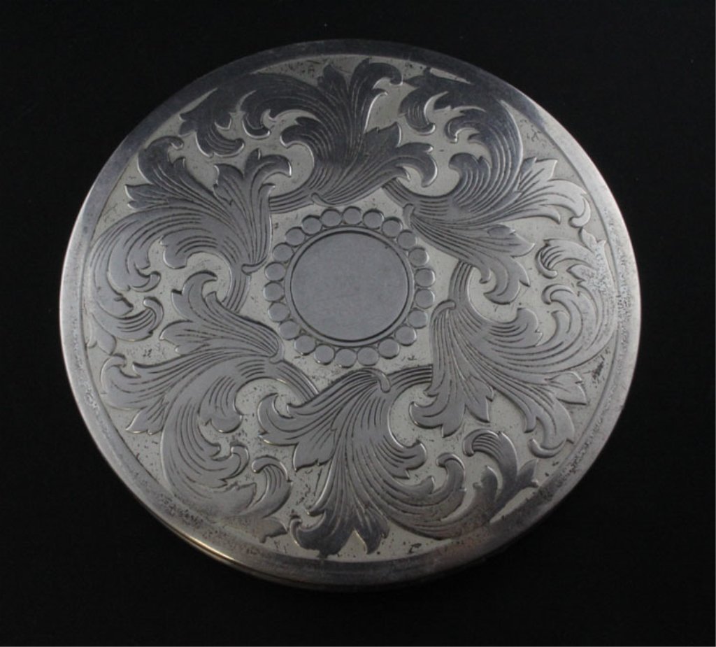 Vintage Sterling Compact: Est. $ 90-135 Vintage Sterling Compact. Label attached to mirror states sterling silver and Rex, lid scrolled with foliage decoration the bottom has engraved decoration, impressed sterling on the side