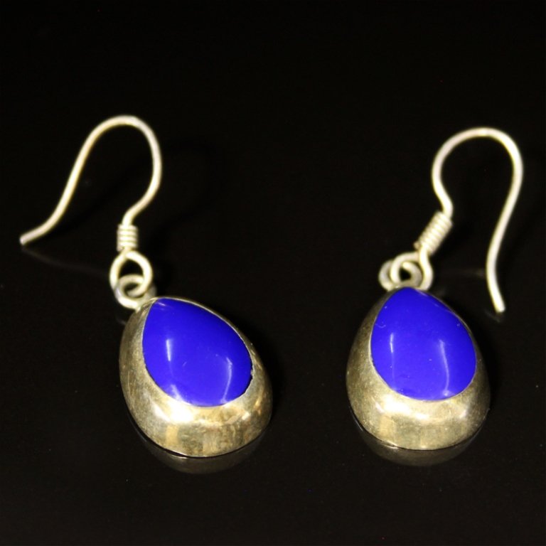 Dangle Style Gemstone Earrings in Sterling: Est. $ 20-50 Dangle Style Gemstone Earrings in Sterling 3.40 grams tw. Drop shaped blue/purple gemstone center in bezel setting. 1 3/8' long.