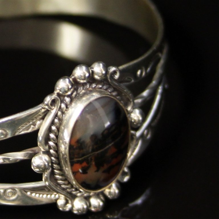 Native American Cuff Bracelet: Est. $ 125-200 Native American Cuff Bracelet Bracelet with gemstone in sterling. 14.5 grams tw. Gemstone: Moss agate, oval cabachon. 15.5 X 11.4mm. 1" widest point. Marks sterling & unknown.