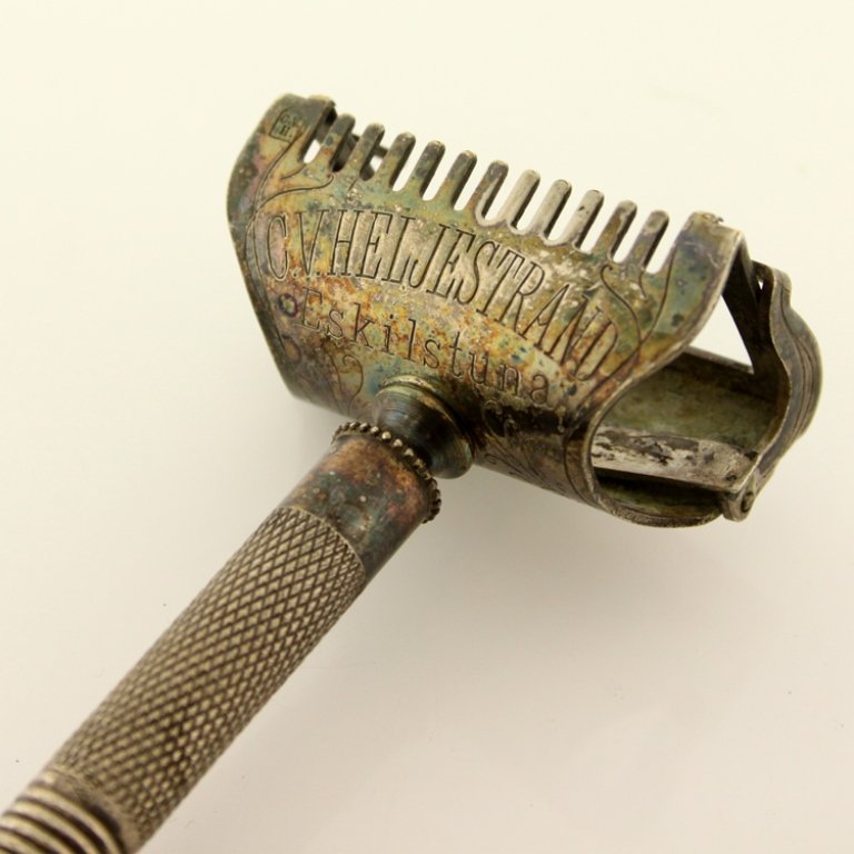 CV Heljestrand Razor: Est. $ 50 - 100 CV Heljestrand Razor Vintage razor. Ornate details on razor head and guard. 2 piece handle. .25 cal bullet shell stuck in base of handle.