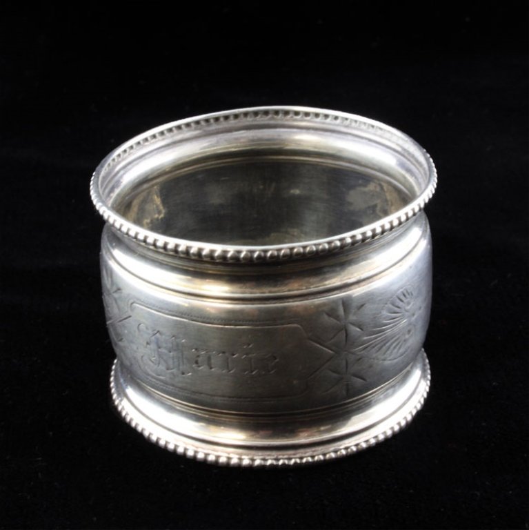 Woods & Hughes Silver Napkin Ring: Est. $ 20 - 30 Woods & Hughes Silver Napkin Ring. Sterling napkin ring, hand etched design around the engraved name Marie, the napkin ring has a beaded boarder on the ends and the inside is stamped wi