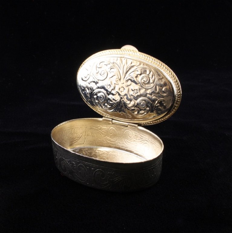 Vintage Pill Box: Est. $ 25 - 40 Vintage Pill Box. Repousse geometric design along the base and the underneath of the lid. The lid has a purple decorated cover encircled by a beaded border. Made of mixed metal with no 