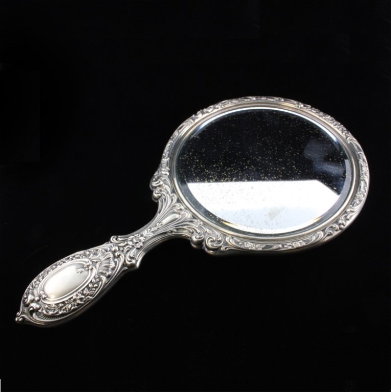 Gorham Sterling Hand Mirror: Est. $ 40-75 Marked Gorham, Sterling and 23. The mirror has a relief/repousse floral design, slight discoloration on the mirror backing. The mirror measures 9 3/4" long x 5 1/2" wide.