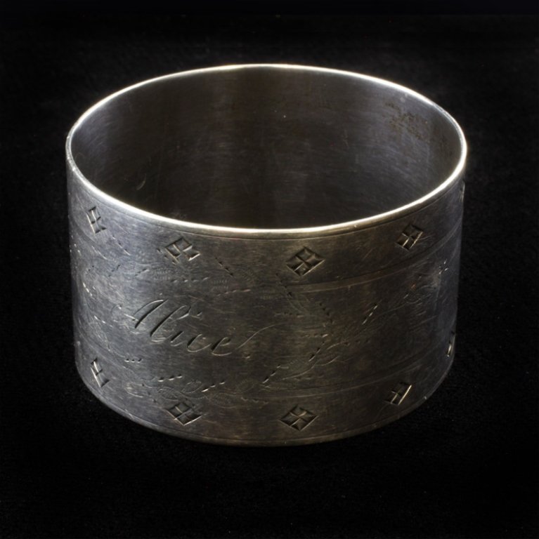 Silver Napkin Ring: Est $ 20-45 Silver Napkin Ring holder with Alice engraved inside an etched floral/ wreath design and a lined geometric border. The napkin ring is marked 413 on the inside, the ring measures 1" tall x