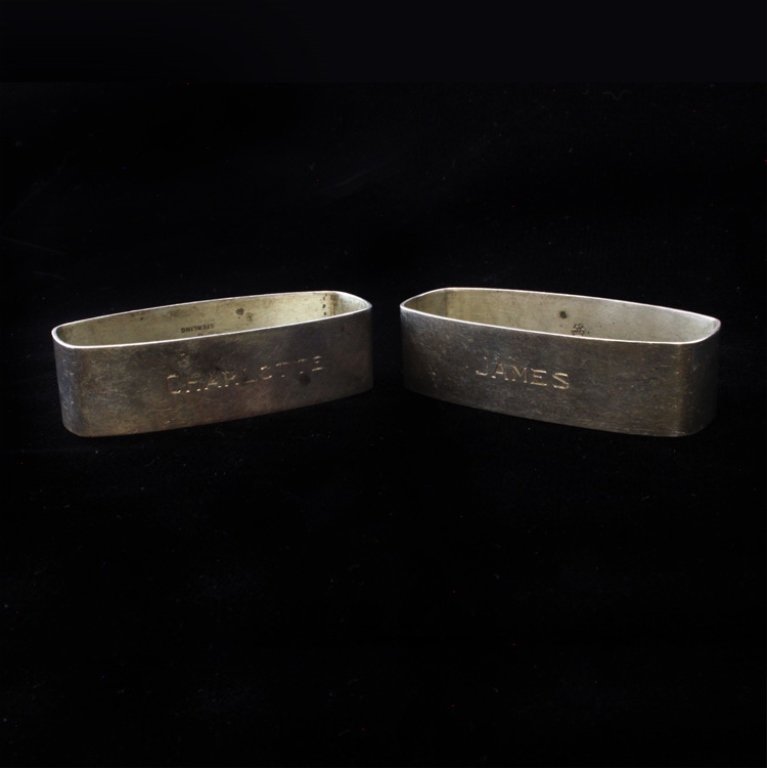 Pair of 2 Manchester Silver Co. Napking rings: Est $ 40-65 Set of two sterling silver oblong napkin ring holders. The holders have a name engraved on each, one reading James and the other is Charlotte. On the inside of the rings is both marked Man