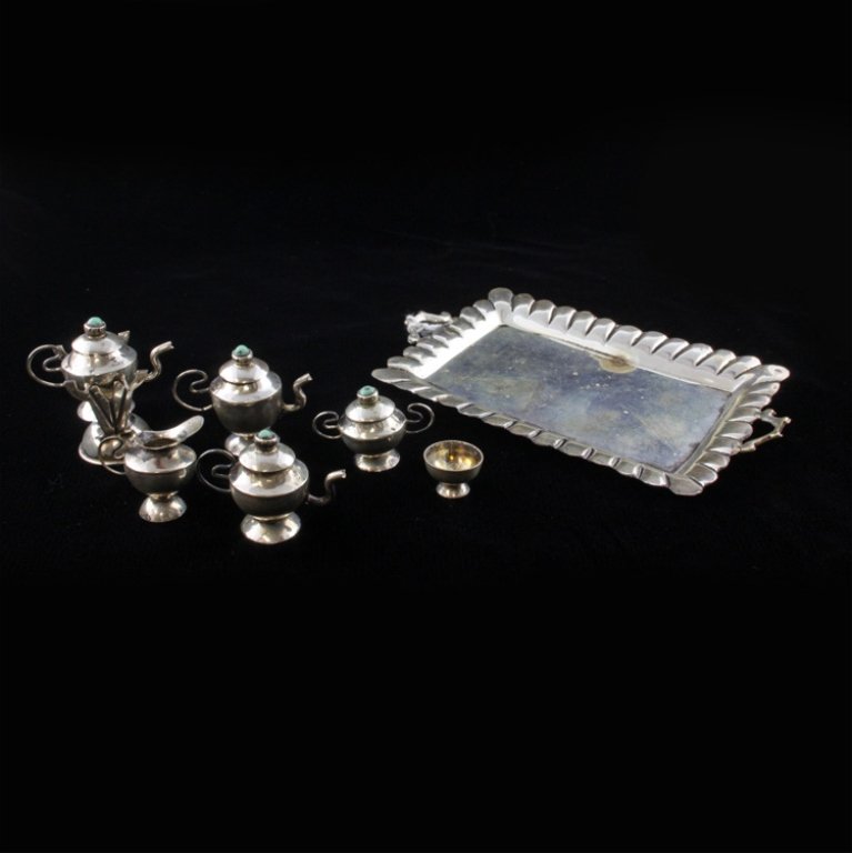 Mexican Miniature Sterling Tea Set: Est $ 45-90 Miniature Sterling Tea Set. Worn makers mark that could possibly be by Hector Aguilar, marked .925. Has slight wear and minor discoloration, includes eight pieces, with green stones as fin