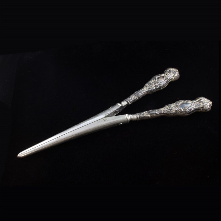 Victorian Sterling Glove Stretcher: Est $ 60-130 Victorian glove stretcher with a relief floral design on the handles. The handles are marked sterling while the tips are marked Pat. Applied For. The glove stretcher measures 7 1/2" long 