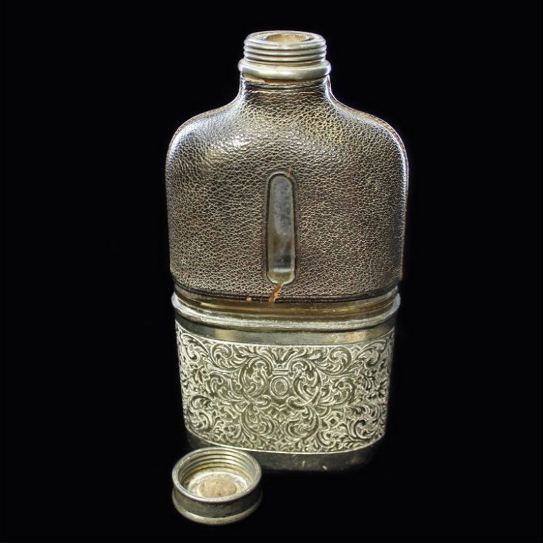 Vintage Silver Plate? and Leather Glass Flask: Est. $ 30-45 Vintage Silver Plated, Leather & Glass Flask. Henry Williams Limited Glass Flask with leather upper cover and silverplated base. Marked H.W.LD on the bottom 6" tall x 3" wide. Leather has