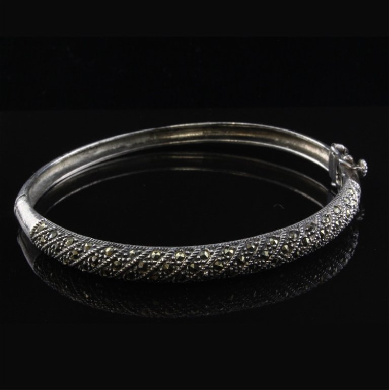 Hinged Bangle Bracelet with Marcasite in Sterling: Est. $ 50 - 75 Hinged Bangle Bracelet with Marcaise in Sterling 13.91 gr. Diagonal set marcasite. 6.40mm at widest point. Marks- 925.