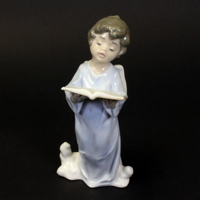 Lladro Porcelain Figure Angelic Voice: Est $ 60-100 Lladro angel singing from a book and standing in the clouds, the title for this figurine is "Angelic Voice" and the sculptor is Francisco Polope. This piece was issued in 1989 and retired