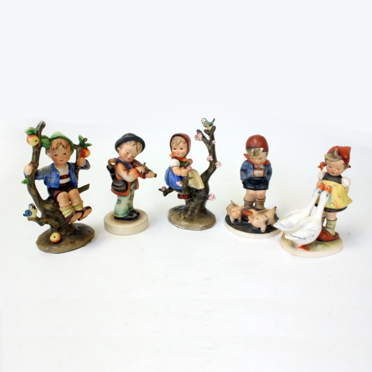 Set of 5 Goebel Hummel Figurines: Hummel Figurines including: Apple Tree Boy, Goose Girl, Farm Boy, Boy playing Violin and Apple Tree Girl. The tallest fingurine the boy sitting on the apple tree is 7" tall, the girl on the apple tree