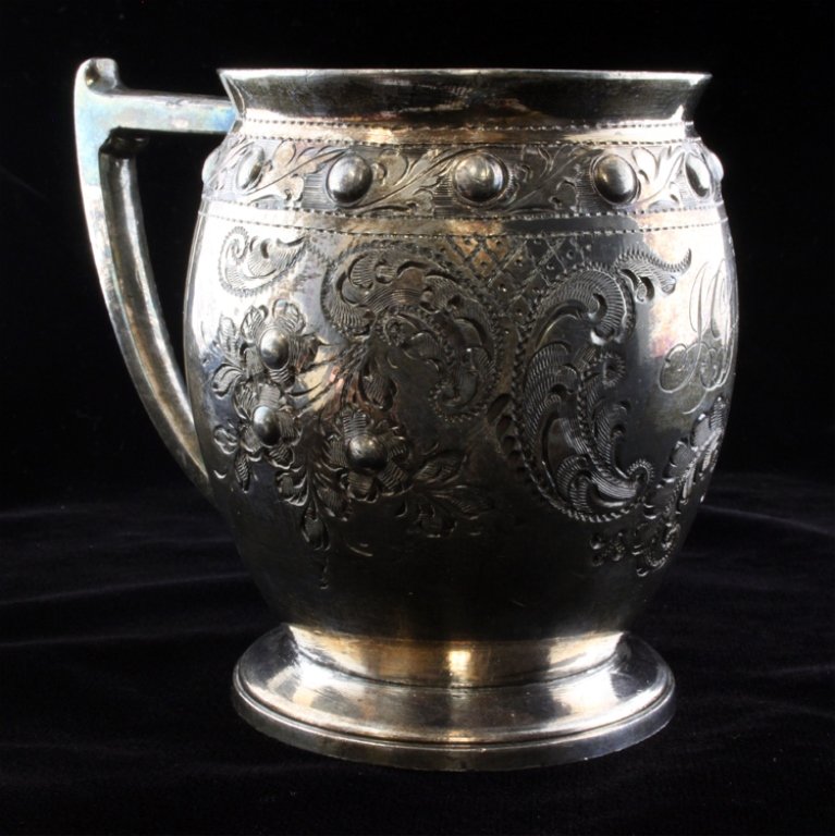 Philip Ashberry & Sons Silver Plate Mug: Est $ 70-120 Silver plate mug made by Philip Ashberry & Sons with an etched floral design with an ornate relief beaded design. The mug has a gold toned interior with a handle and footed bottom. The cu