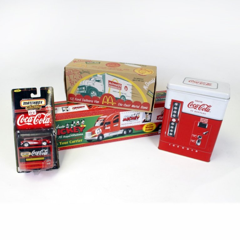 Set of Four Vintage Collectables: Est $ 300-400 Set of four Coca-Cola collectables including: a McDonald's 53' Fork Delivery Van Die-Cast Metal Bank, a 1957 Corvette Convertible matchbox car that has come unattached from the cardboard