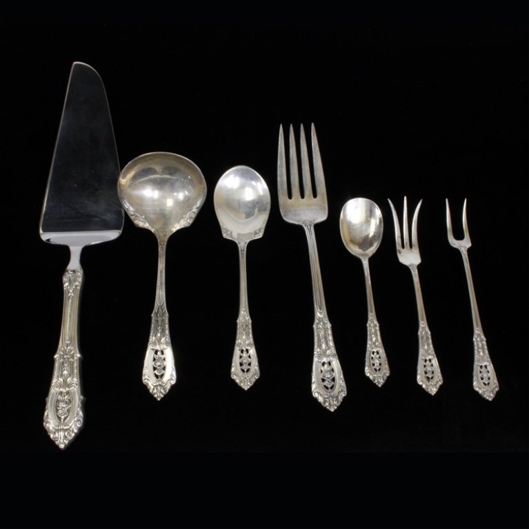 Set of 7 Wallace Rose Point Silverware: Est $ 500-700 Set of 7 silverware set made by Wallace Silversmiths with the1934 Rose Point pattern designed by William S. Warren. The set includes: Wallace sterling handle, stainless blade cake server