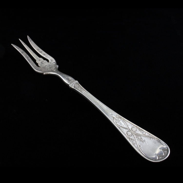 Sterling Brite Cut Lemon Fork: Est $ 60-100 Sterling lemon fork that does not bear a makers mark. The fork is 3 tine with a brite cut pattern ornamenting the handle and the tines. The fork measures 5 3/4" long x 3/4" at the widest 