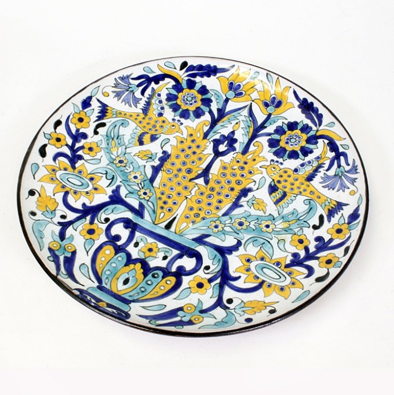 Decorative Signed Middle Eastern Plate: Est $ 150-300 Ceramic hand painted plate decorated with a yellow, blue, green floral and bird motif. The plate is signed on the back and measures 14" in diameter.